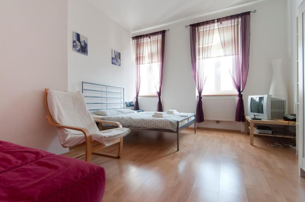 - un salon avec un lit, une chaise et une télévision dans l'établissement Premium Apartments Klimschgasse, à Vienne