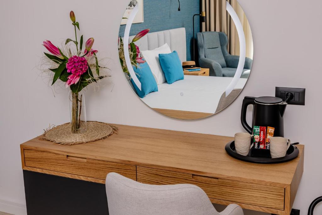 a room with a table with a mirror and a bed at Hotel AQUILO in Petrovac na Moru