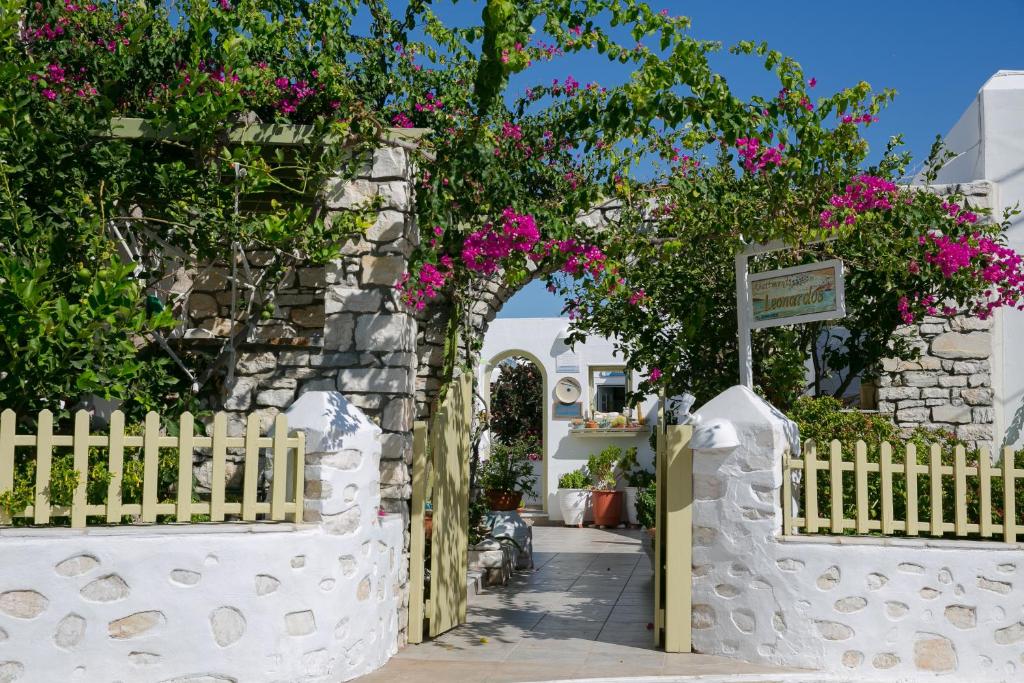 a white fence with a gate with pink flowers at Leonardos Apartments in Naousa