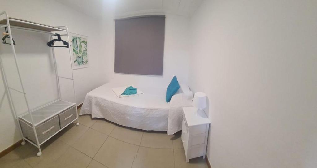 Habitación blanca pequeña con cama pequeña. en La Casablanca, en Pasito Blanco