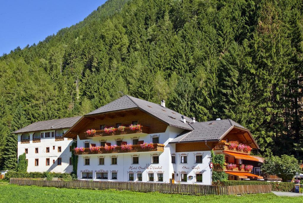 a large building with flowers on the side of it at Hotel Bad Winkel in Campo Tures