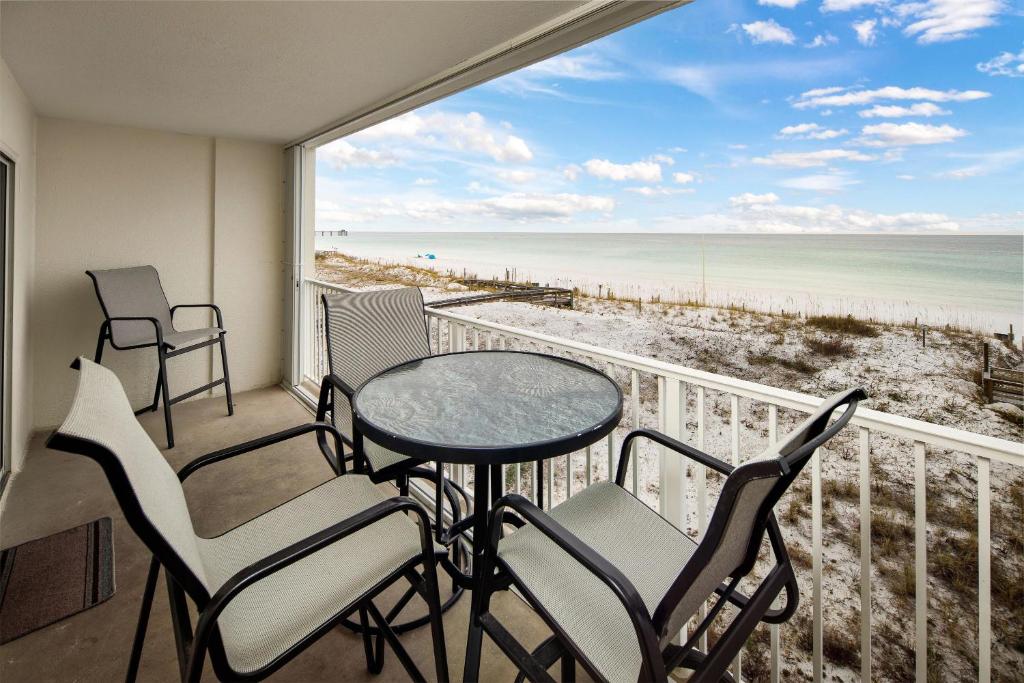 un balcone con tavolo e sedie e vista sulla spiaggia di Gulf Dunes 302 a Fort Walton Beach