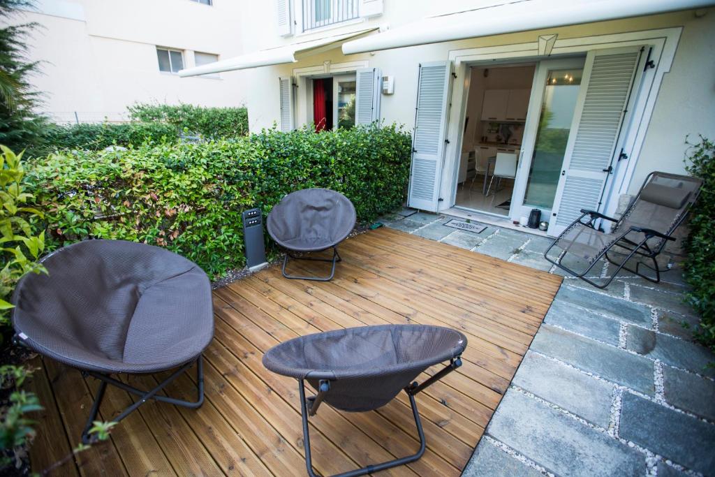 2 chaises et 2 tables sur une terrasse en bois dans l'établissement Résidence Les Palmiers by Connexion, à Cannes