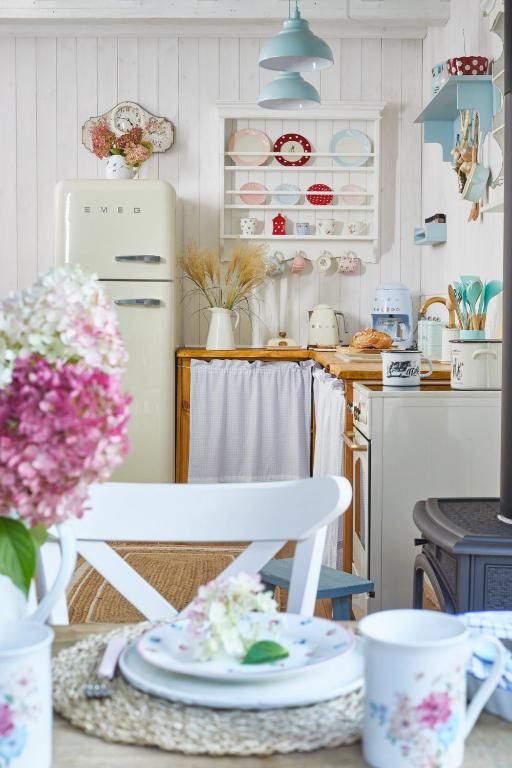a kitchen with a white refrigerator and a table with flowers at Miejscówka nad Morzem in Ciekocino