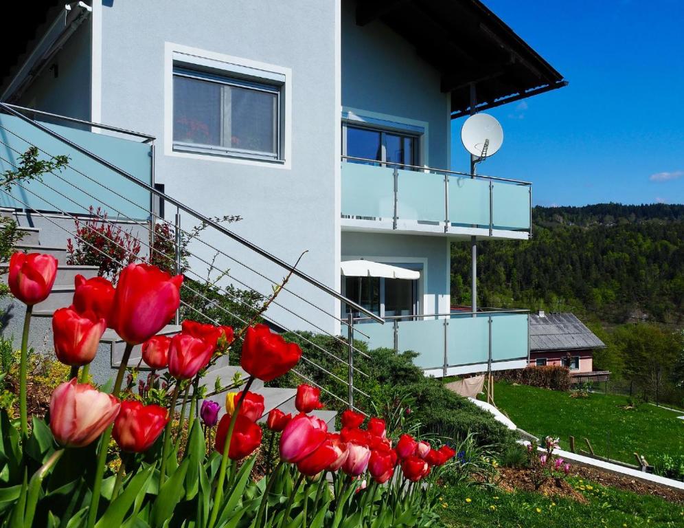 a bunch of red tulips in front of a house at Ferienwohnung Margarethe in Velden am Wörthersee