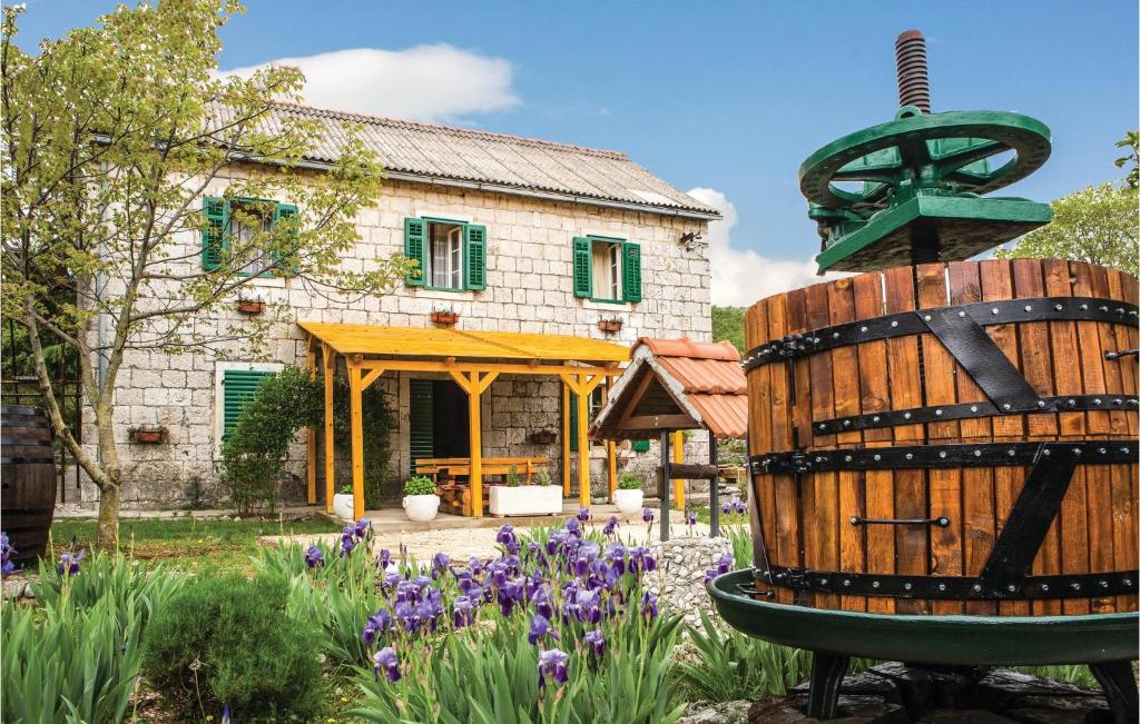 une maison avec un jardin orné de fleurs violettes dans l'établissement Three-Bedroom Holiday Home In Lecevica, à Lećevica