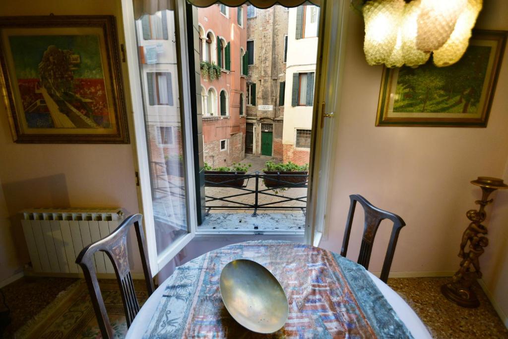 mesa y sillas en una habitación con ventana en Ve.N.I.Ce. Cera Casa Del Sol, en Venecia