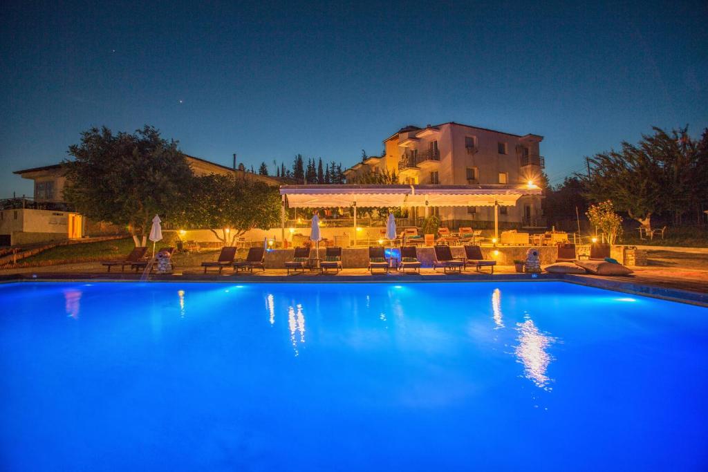 a large blue swimming pool with a building in the background at Tselikas Hotel in Kozani