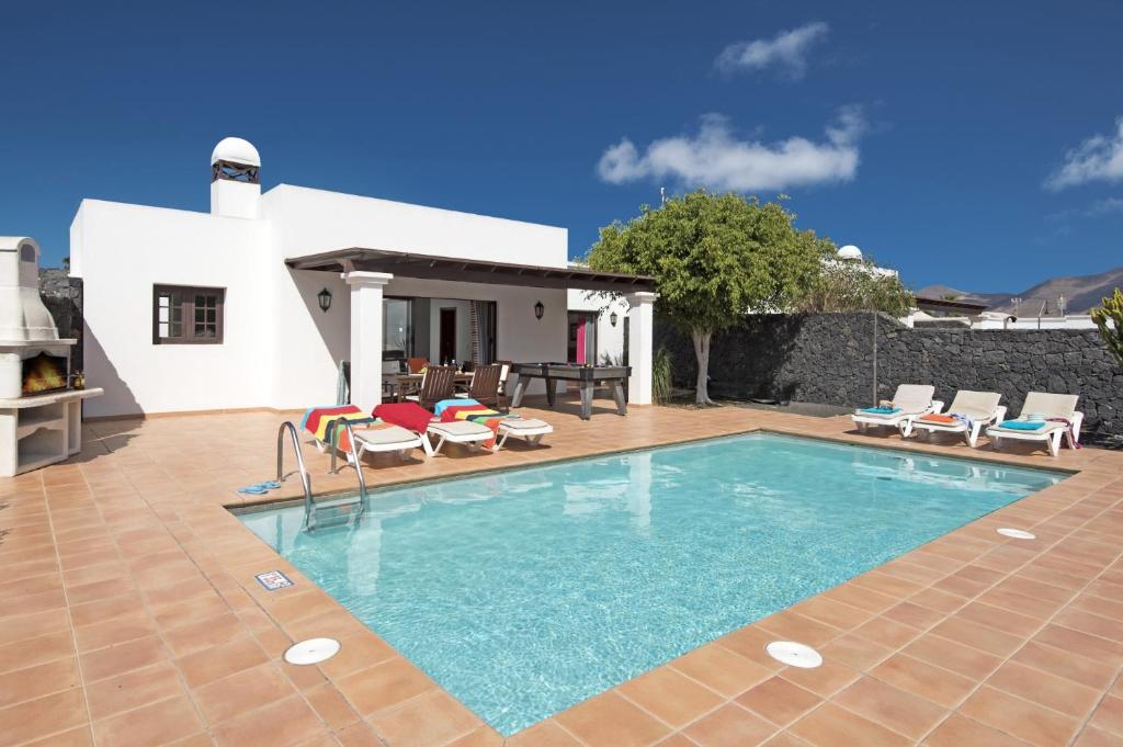 una piscina frente a una villa en Villa Flamingo by Villa Plus, en Playa Blanca