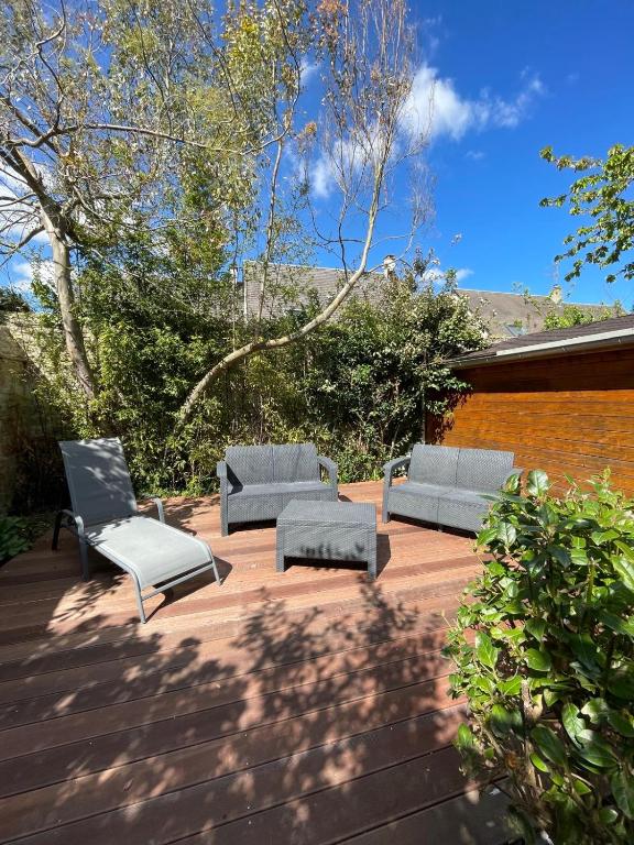 d'une terrasse avec deux canapés et des chaises. dans l'établissement Chalet dans jardin privatif, à Caen
