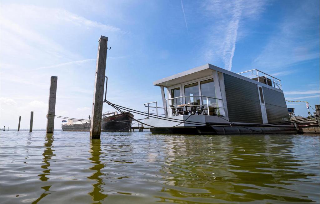 a house boat docked at a dock in the water at Cozy Ship In Biddinghuizen in Biddinghuizen