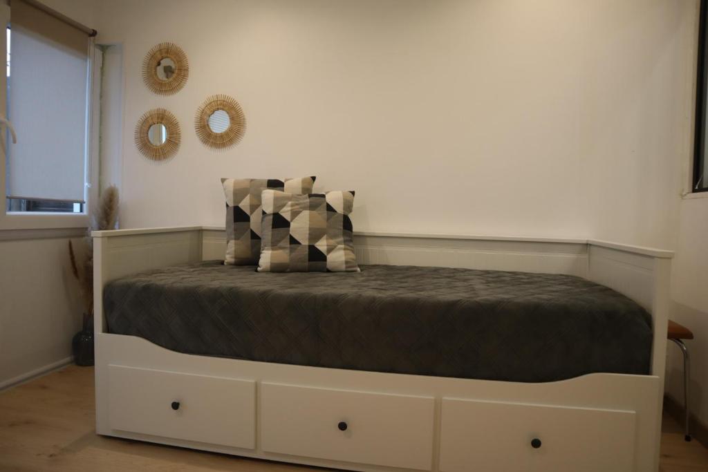 - une chambre avec un lit et une couette brune dans l'établissement Maisonnette au porte des vignes, à Gradignan