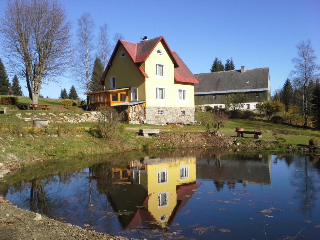 una casa con un estanque delante de ella en Chata Rybná 18 en Pernink