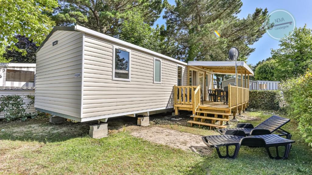 une petite maison avec un porche et une terrasse dans l'établissement Le Bois Masson 130 by Nova, à Saint-Jean-de-Monts