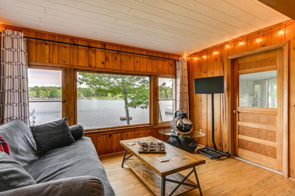 a living room with a couch and a table at Hale Rustic Retreat on Long Lake Near Boat Launch! in Hale