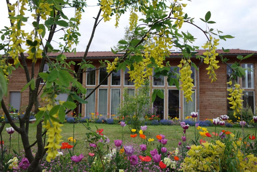 einen Garten vor einem Haus mit Blumen in der Unterkunft Maison Addama in Neyron