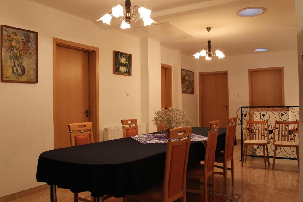 a dining room with a black table and chairs at Pacsirta Vendégház in Egerszalók