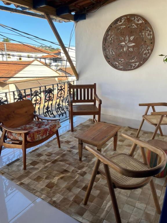 a patio with chairs and tables on a balcony at Pouso Bem Estar in Tiradentes