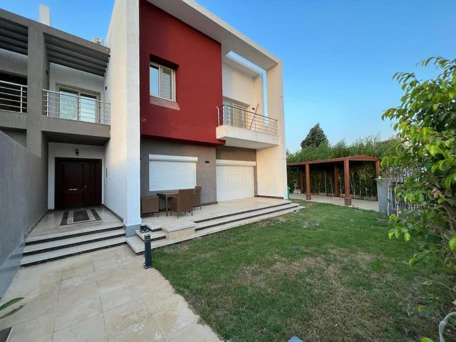 a red house with a yard in front of it at Villa Nagy in Madinaty