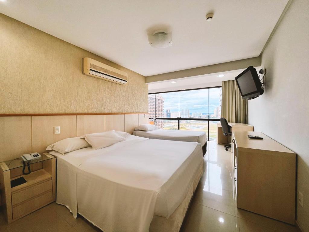 Una habitación de hotel con dos camas y un televisor. en 1138 Flat Triplo Garvey - Esplanada e Congresso, en Brasilia