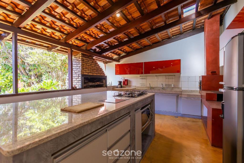 a kitchen with red cabinets and a counter top at Casa Charmosa c/ Churrasq/ na Vila Planalto ACT029 in Brasilia