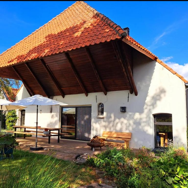 a house with a large roof with a patio at Hof van Eden in Ophemert