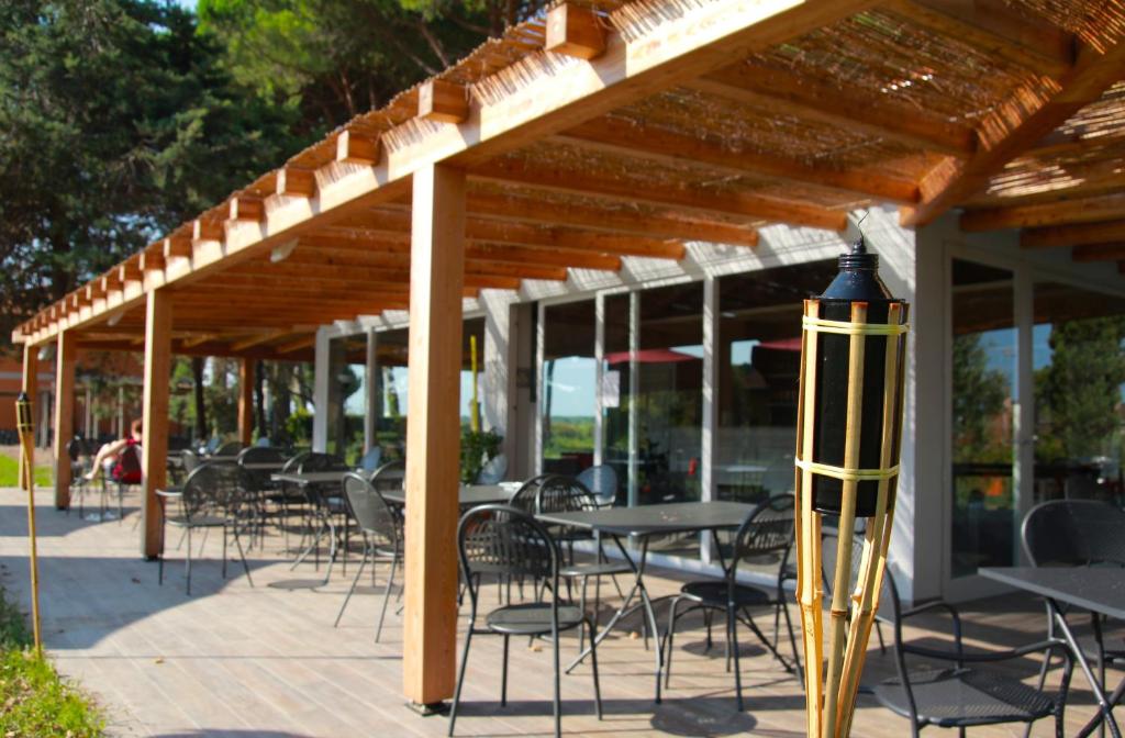 a group of tables and chairs under a wooden pergola at La Fattoria di Tirrenia in Tirrenia