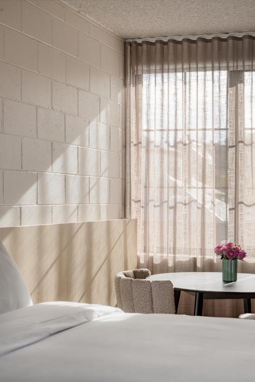 Hotel MAC Richmond by Melbourne Apartment Collection, a bedroom with a bed and a table and a window at MAC Richmond by Melbourne Apartment Collection in Melbourne