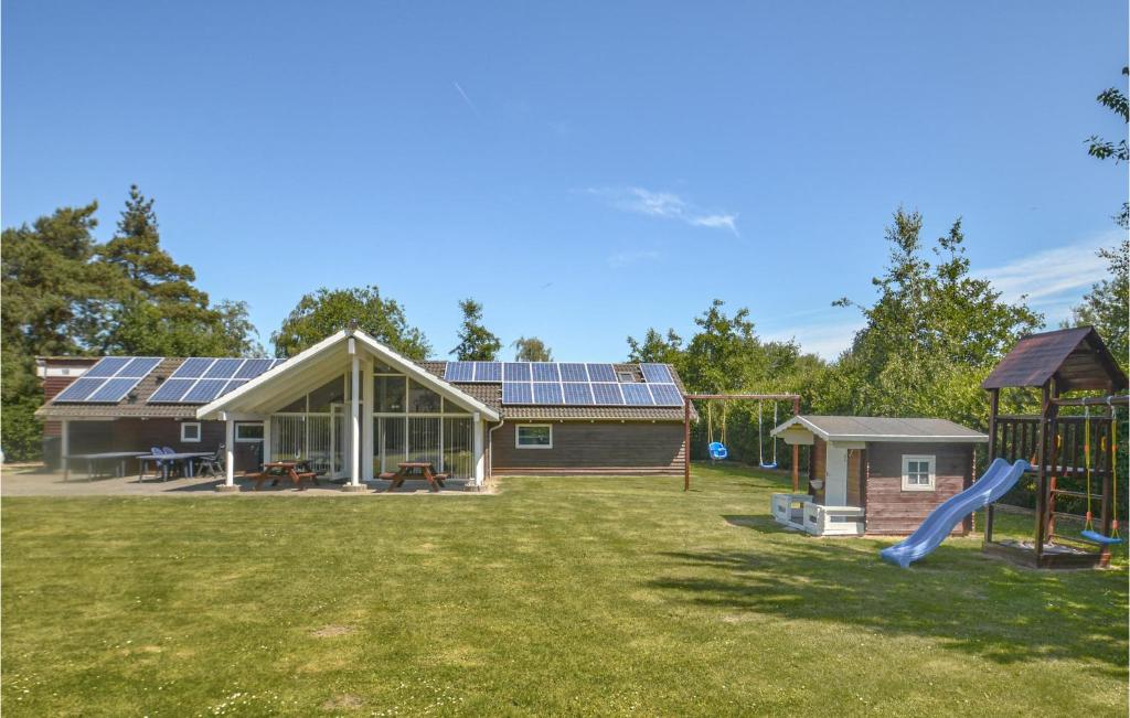 a house with solar panels on the roof and a playground at Holiday Home Musestien Dnmk Ii in Marielyst