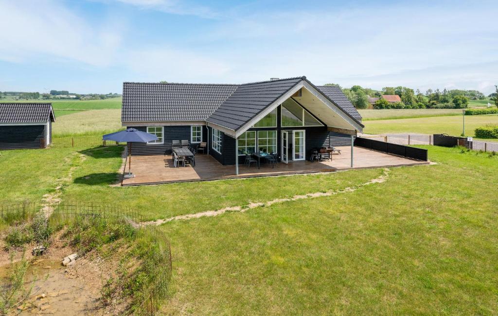 a small house with a deck in a field at Four-Bedroom Holiday Home In Bagenkop in Bagenkop