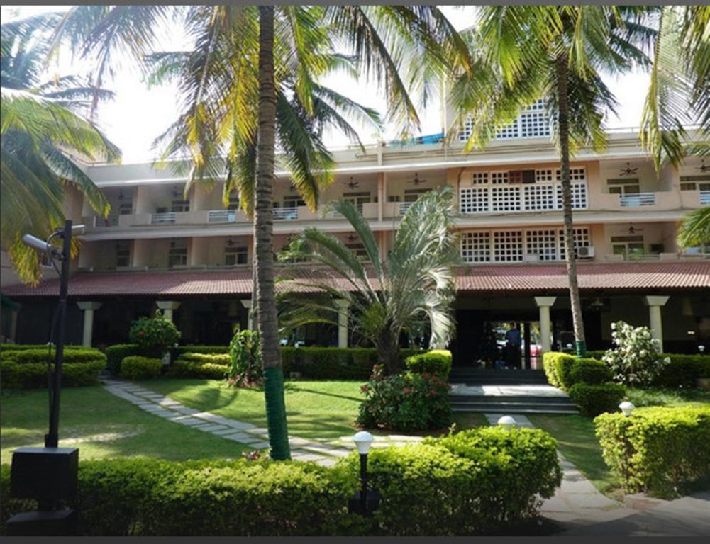 un gran edificio con palmeras delante en Royal Orchid Resort & Convention Centre, Yelahanka Bangalore en Bangalore