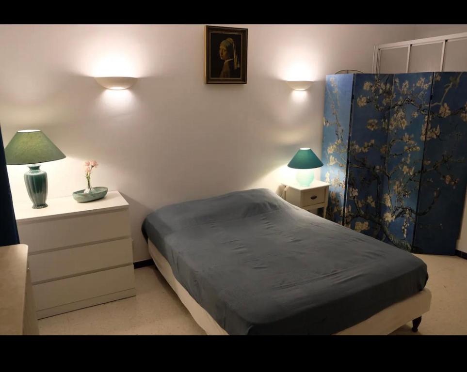 - une chambre avec un lit, deux tables et deux lampes dans l'établissement Appart sunshine, à Sainte-Tulle