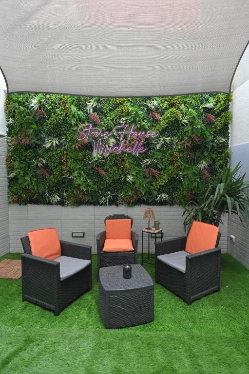 a green wall with two chairs and a table at Stone House Michelle in Torre Annunziata