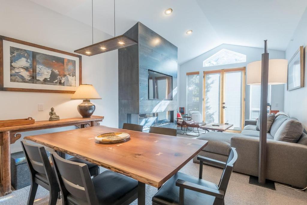 Una sala de estar con una mesa y sillas de madera. en Snowstar Condo 23, en Ketchum