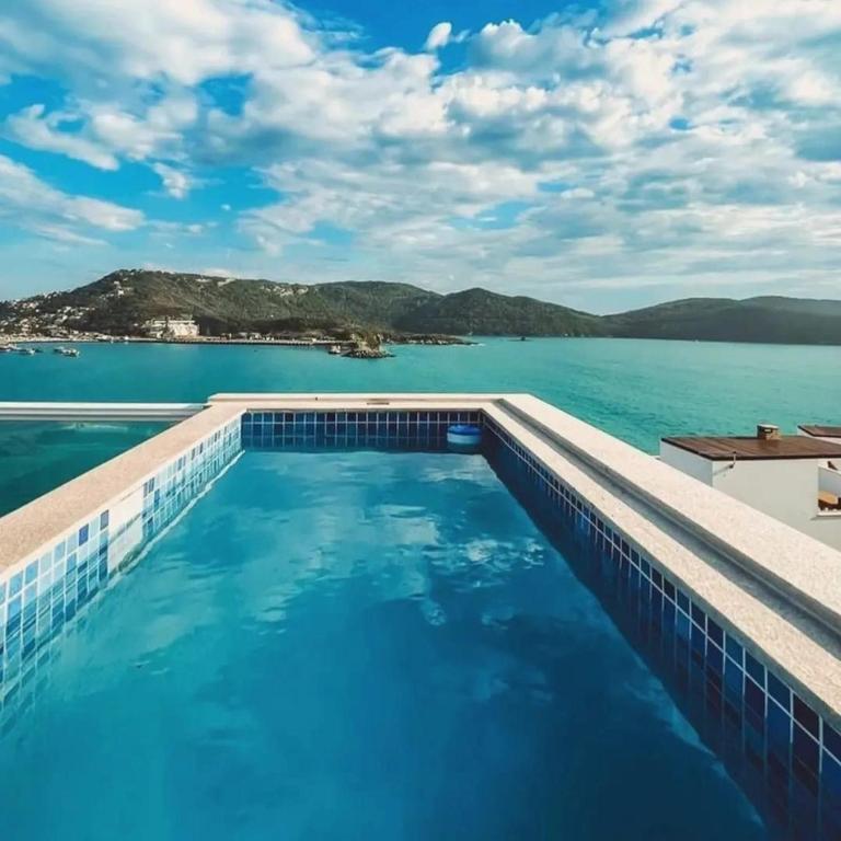 a swimming pool with a view of the water at Casa Ibiza - Pontal do Atalaia - Arraial do Cabo in Arraial do Cabo