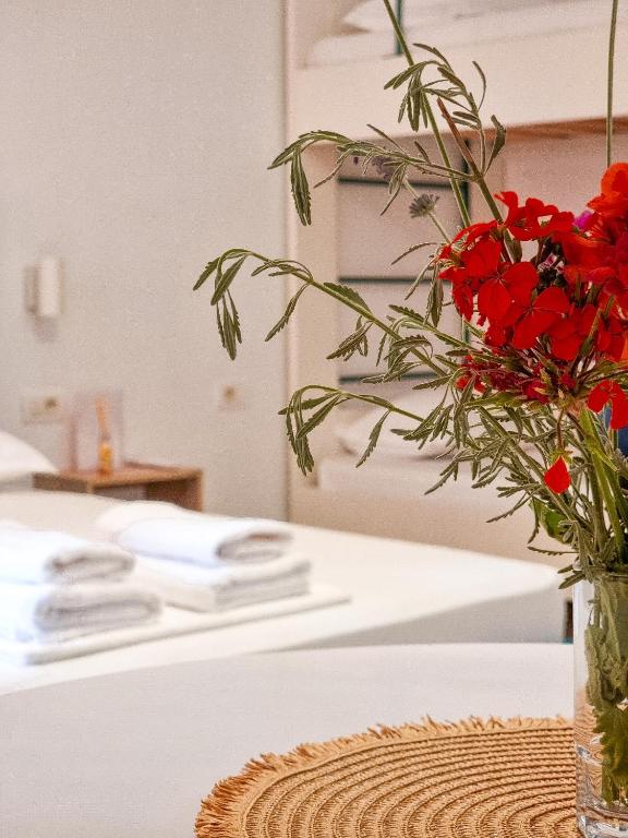 a vase filled with red flowers sitting on a counter at Arte Apartment in Sarandë
