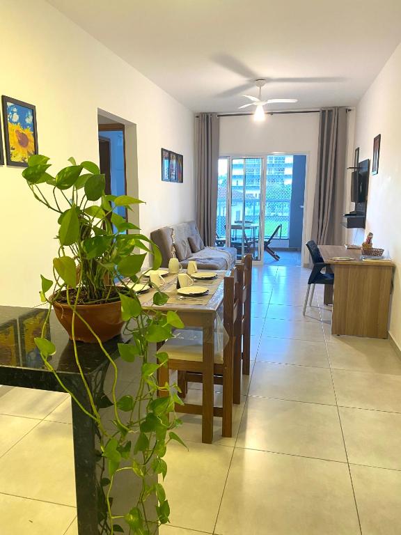 a living room with a table and a dining room at Ap no centro piscina e churras in Ubatuba