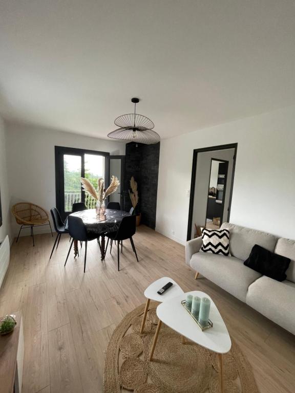 un salon avec un canapé et une table dans l'établissement Maison 2 chambres, à Coucouron