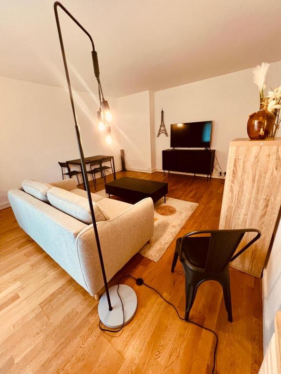 un salon avec un canapé et une télévision dans l'établissement Disney-Bord de Marne-Parking Privé, à Meaux