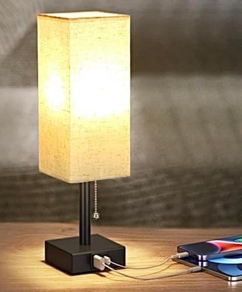 a lamp sitting on top of a wooden table at Elite Summer Suite in Năvodari
