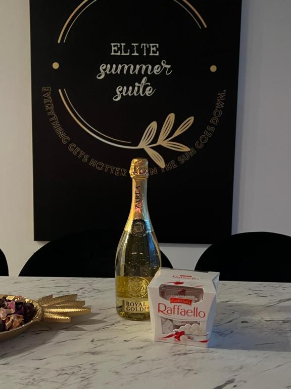 a bottle of wine sitting on top of a table at Elite Summer Suite in Năvodari