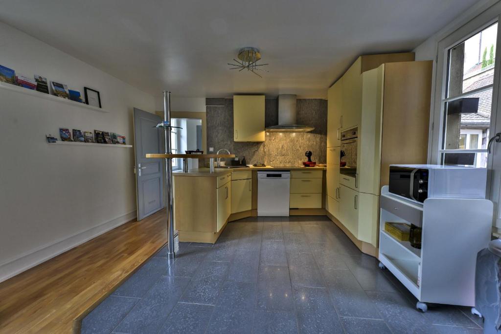 une grande cuisine avec des armoires jaunes et des appareils blancs dans l'établissement i-love-colmar - Le 8 de Coeur - Garage gratuit, à Colmar