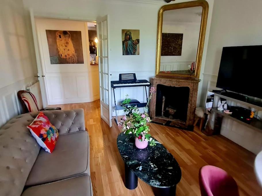 un salon avec un canapé, une table et un miroir dans l'établissement Apparemment zone olympique, à Paris