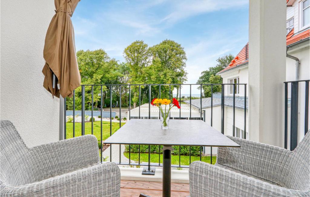 a patio with two chairs and a table with a vase of flowers at Baltischer Hof Apartment 43 in Boltenhagen
