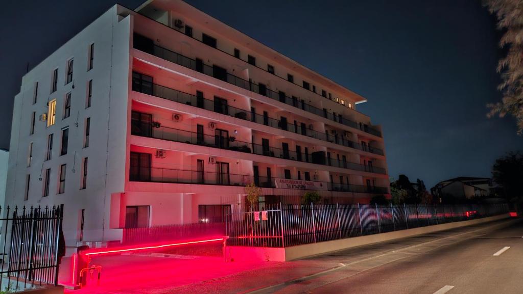 a large building with pink lighting in front of it at Luxury 2 bed apartment by Albert in Roşu