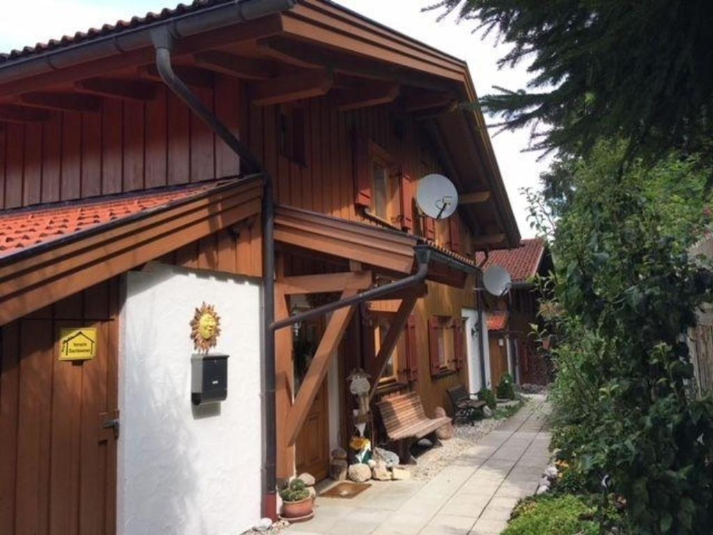 a person sitting on a balcony of a building at Ferienhaus in ruhiger Lage, mit Balkon, Terrasse und eigenem Gartenteil in Aschau im Chiemgau