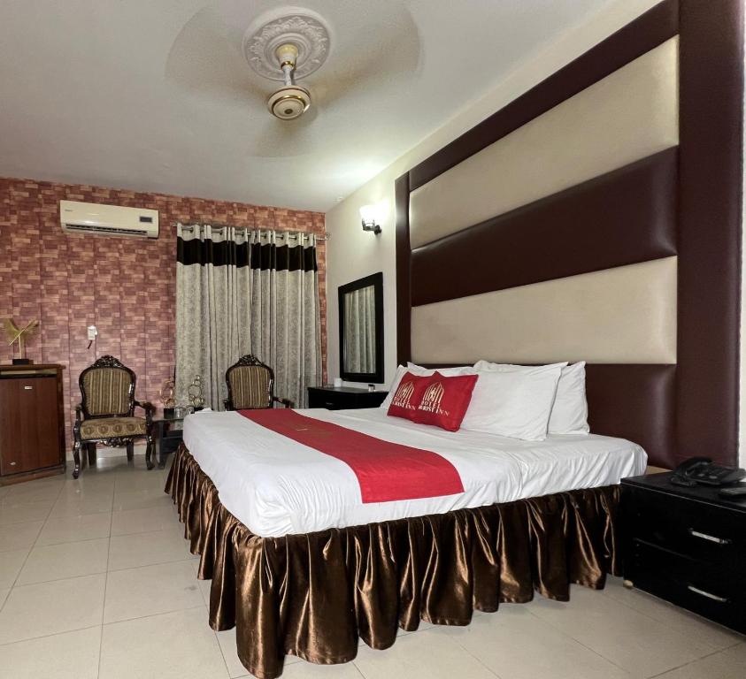 a hotel room with a large bed with a red blanket at HOTEL TOURIST INN in Lahore