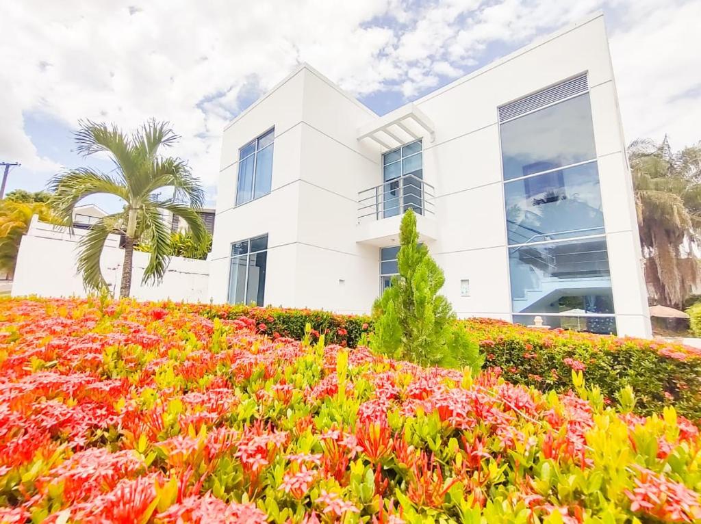 una casa bianca con dei fiori davanti di Bellísima casa quinta capacidad 20 personas a Melgar
