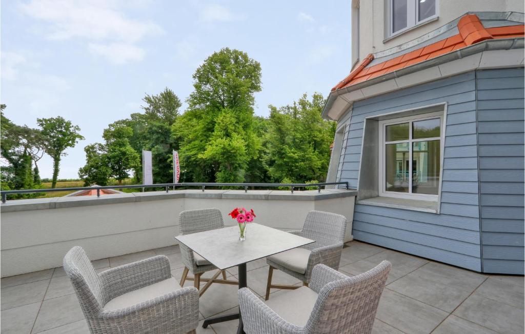 a patio with chairs and a table with a vase of flowers at Baltischer Hof Apartment 21 in Boltenhagen