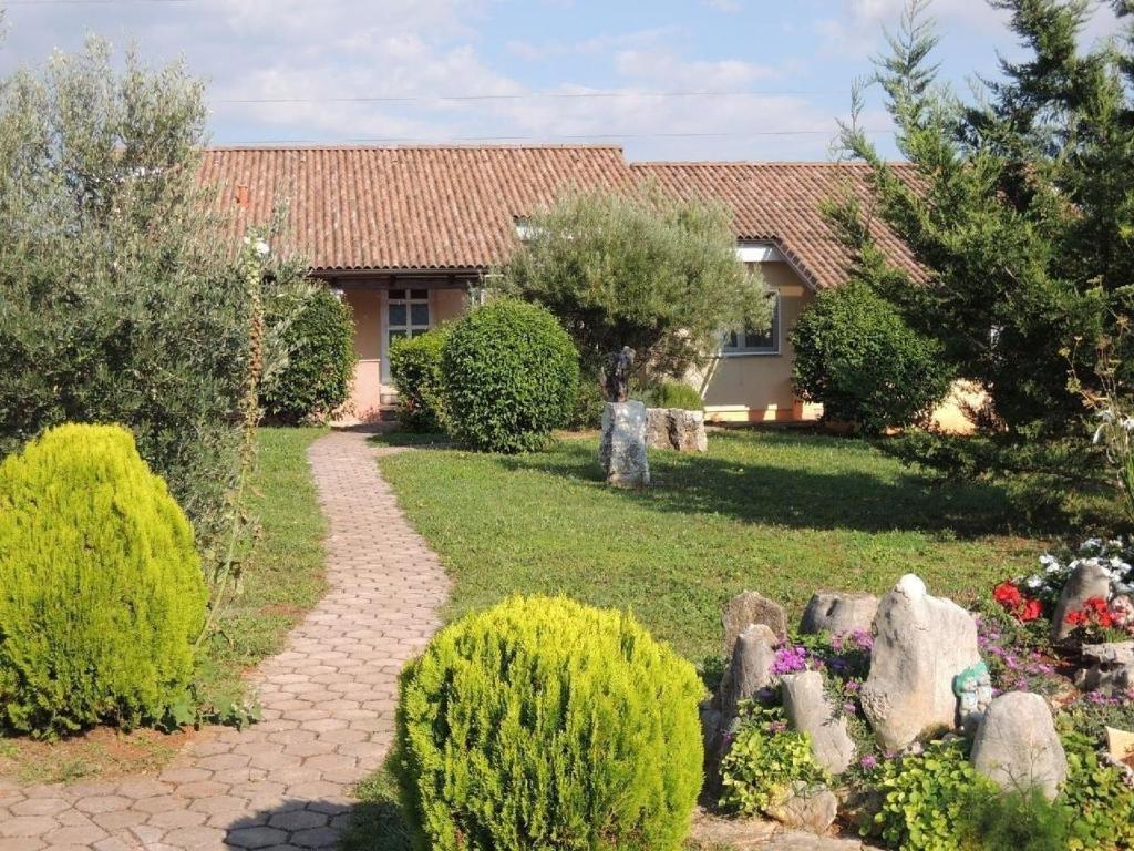 a garden with a pathway leading to a house at Bungalow Melisa mit Salzwasserpool in Porec in Poreč